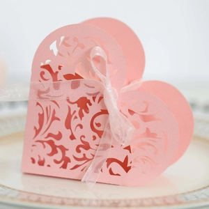 Dettaglio scatola regalo a cuore rosa traforata con nastro elegante per nozze