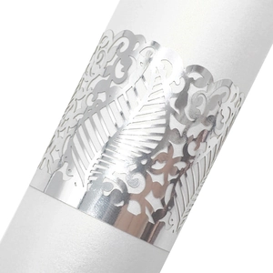 Macro detail of silver laser-cut paper napkin ring with elegant mirror vine pattern