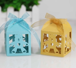 Detailed laser-cut candy boxes with hollow bear design and elegant organza ribbons