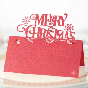 Macro shot of laser-cut Merry Christmas red glitter place card with snowflake detail