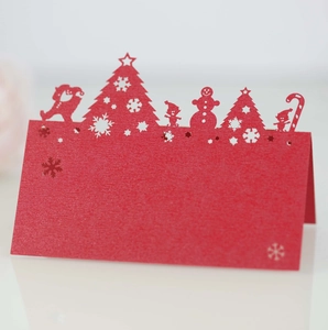 Detailed laser-cut red Christmas place cards featuring Santa, trees, and snowflake cutouts