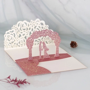 Macro view of 3D laser-cut wedding card featuring pink glitter and floral paper silhouette