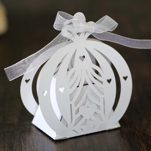Close-up of laser-cut pumpkin carriage candy box with heart details and white ribbon