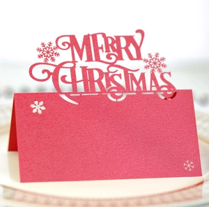 Laser cut Christmas table card in red pearlescent paper with Merry Christmas cutout