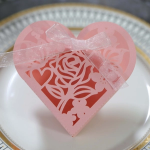 Détails de roses découpées au laser sur une boîte cadeau rose en forme de cœur avec ruban
