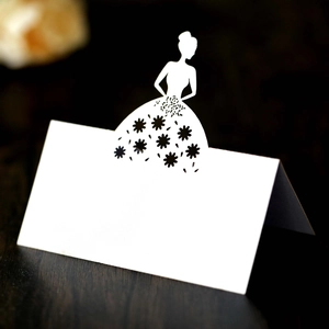 Detail of white laser-cut bride silhouette table card with floral lace patterns