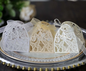 Detailed laser-cut wedding favor boxes with butterfly patterns and satin ribbons