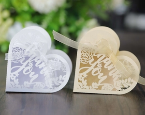 Close-up of heart-shaped laser-cut favor boxes with Thank You text and ribbons