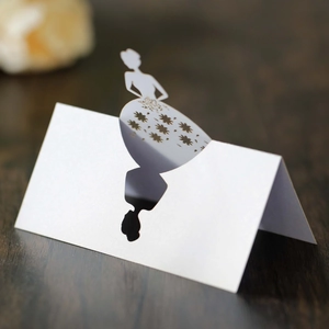 Close-up of laser-cut white place card with elegant female silhouette for table settings