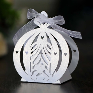 Macro shot of white laser-cut pumpkin carriage gift box with heart pattern and ribbon