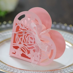 Détail de la rose découpée au laser sur une boîte cadeau rose en forme de cœur avec ruban