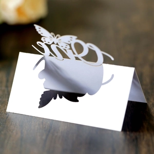 Macro detail of laser-cut butterfly place card with Mrs text on white pearlescent paper