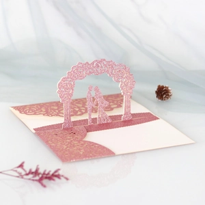 Detail of pink glitter 3D pop-up wedding card with laser-cut rose arch and couple