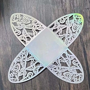 Flat lay of laser-cut white wedding favor box template with butterfly hollow pattern