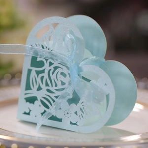 Gros plan d'une boîte cadeau bleu clair en forme de cœur avec roses découpées au laser