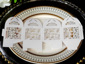 Flat lay detail of laser-cut floral pattern and thank you text on white gift box