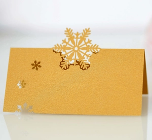 Détail de la carte de table flocon de neige dorée découpée au laser avec texture nacrée