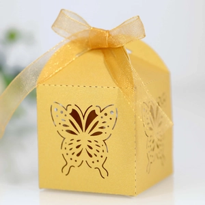 Detail of laser-cut butterfly candy box in gold finish with elegant organza ribbon bow