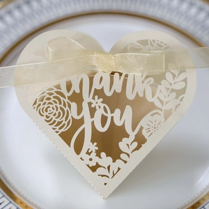 Macro shot of laser-cut Thank You lettering and intricate floral patterns on cream favor box