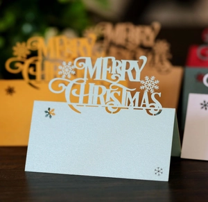 Detailed laser-cut Merry Christmas place card with snowflake pattern in pearlescent paper