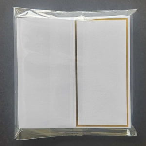 Detailed view of white butterfly place card with gold border in transparent packaging