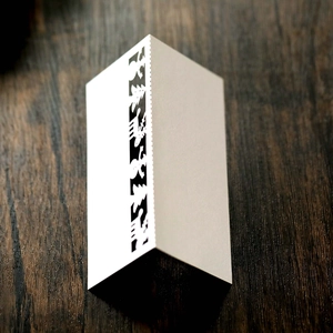 Close-up of white card featuring laser-cut Christmas reindeer and snowman patterns