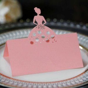 Macro detail of pink laser-cut butterfly place card with floral patterns on a white plate