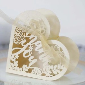 Close-up of laser-cut heart favor box with elegant Thank You script and ribbon