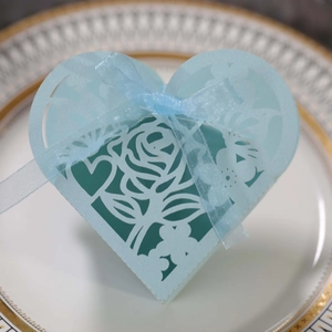 Détail de la boîte cadeau coeur bleu clair avec rose découpée au laser et ruban de satin