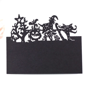 Halloween place cards with laser-cut silhouettes of pumpkins, witches, and spider webs