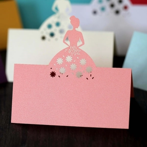 Macro shot of laser-cut pink place card with bridal silhouette and pearlescent finish