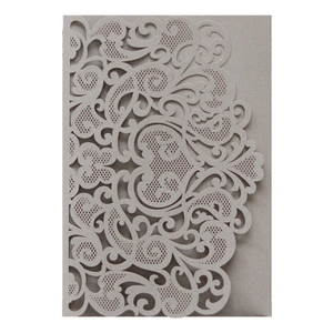 Close-up of laser-cut floral patterns on pearlescent grey wedding invitation card