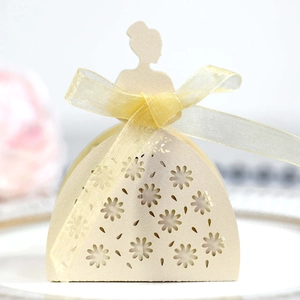 Detail of laser-cut dress-shaped favor box with cream pearl paper and yellow ribbon bow