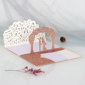 Detail of 3D pop-up rose gold wedding invitation with laser-cut flowers and silhouette