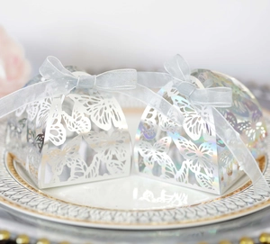 Detailed laser cut butterfly candy gift box with blue ribbon on elegant white plate