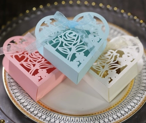 Détails de motifs roses et cœurs découpés au laser sur boîtes cadeaux avec rubans