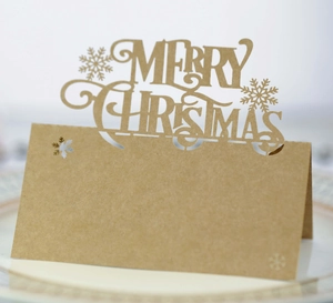 Macro detail of laser-cut Merry Christmas lettering on kraft paper table seating card