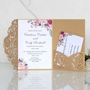 Detail of laser-cut navy rose wedding invitation set on marble with card inserts