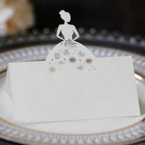 Macro view of laser-cut white seat card with floral silhouette on ceramic plate