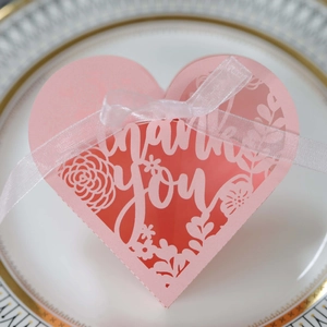 Macro detail of pink heart-shaped laser-cut gift box with floral pattern and ribbon