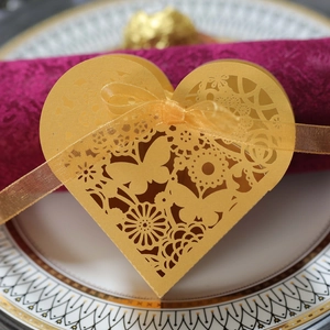 Detailed laser-cut heart favor box with butterfly patterns and gold ribbon for weddings