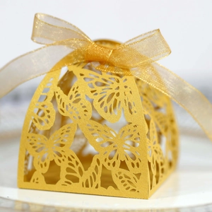 Close-up of laser-cut butterfly hollow gift box with golden ribbon bow decoration