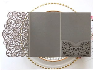 Close-up of dark grey laser-cut invitation cover with intricate floral scrollwork patterns