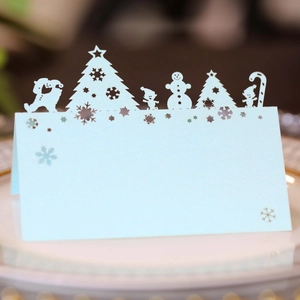 Macro shot of light blue Christmas place cards with laser-cut gingerbread and snowman