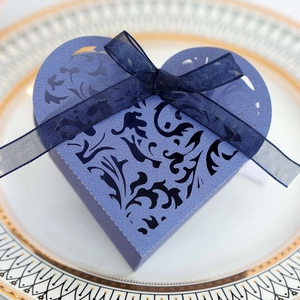 Macro di scatola regalo a cuore con intaglio laser e fiocco di nastro blu profondo