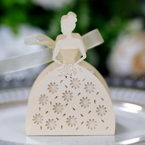 Macro detail of laser-cut ivory bridal dress favor box with floral pattern and ribbon