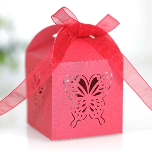 Macro detail of laser-cut butterfly pattern and red organza ribbon on the candy box