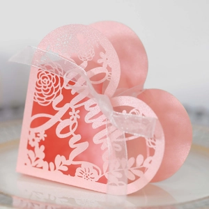 Detail of pink heart-shaped laser cut wedding gift box with Love text and ribbon