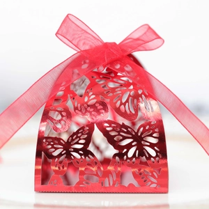 Red metallic wedding favor box with laser-cut butterfly patterns and a ribbon bow
