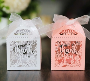 Close-up of laser-cut Thank You gift boxes with silk ribbon bows in white and pink colors